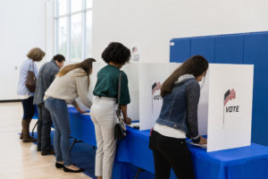A group of adults vote at a table